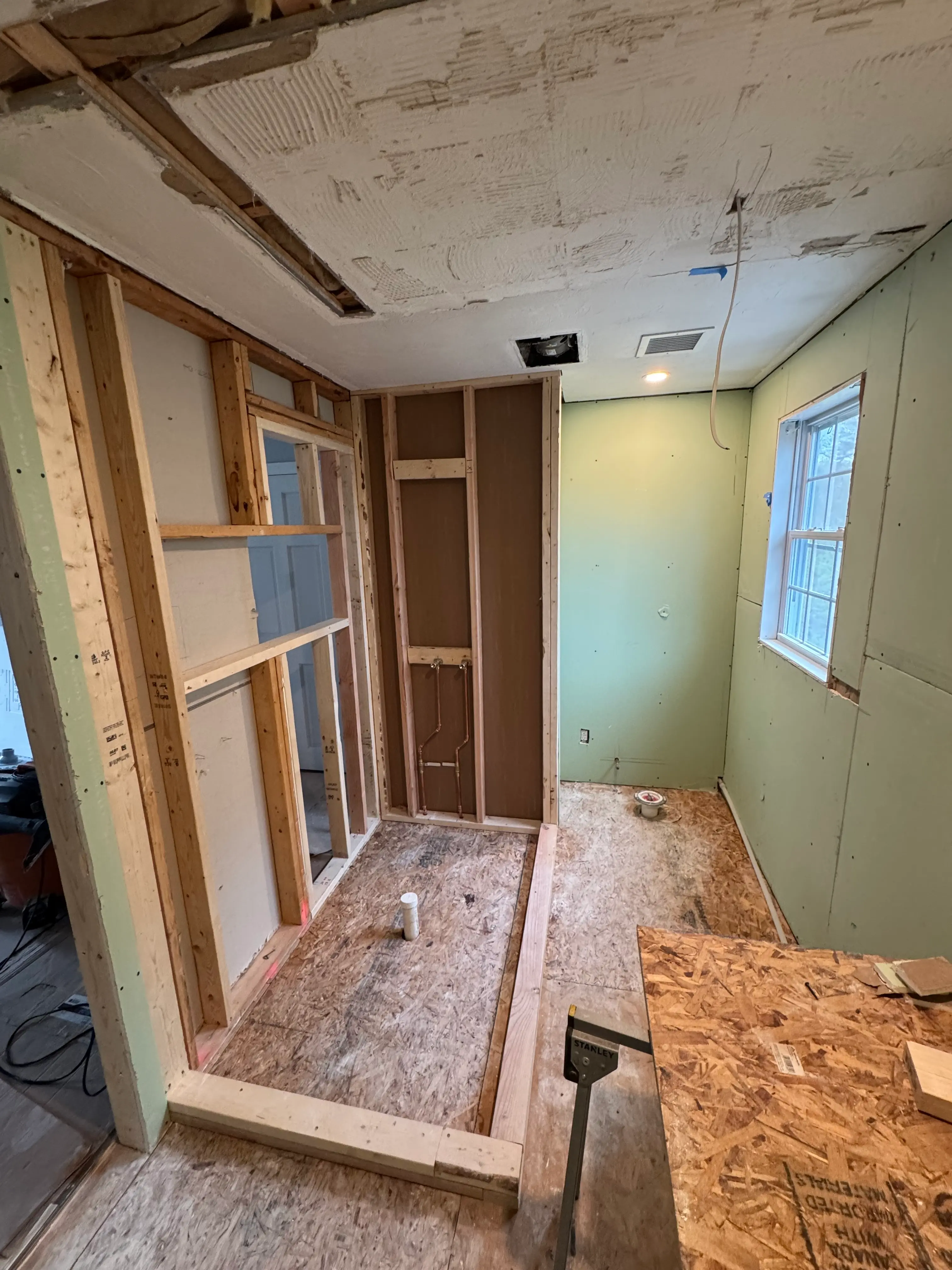 Shower walls and base prepared around plumbing rough-ins